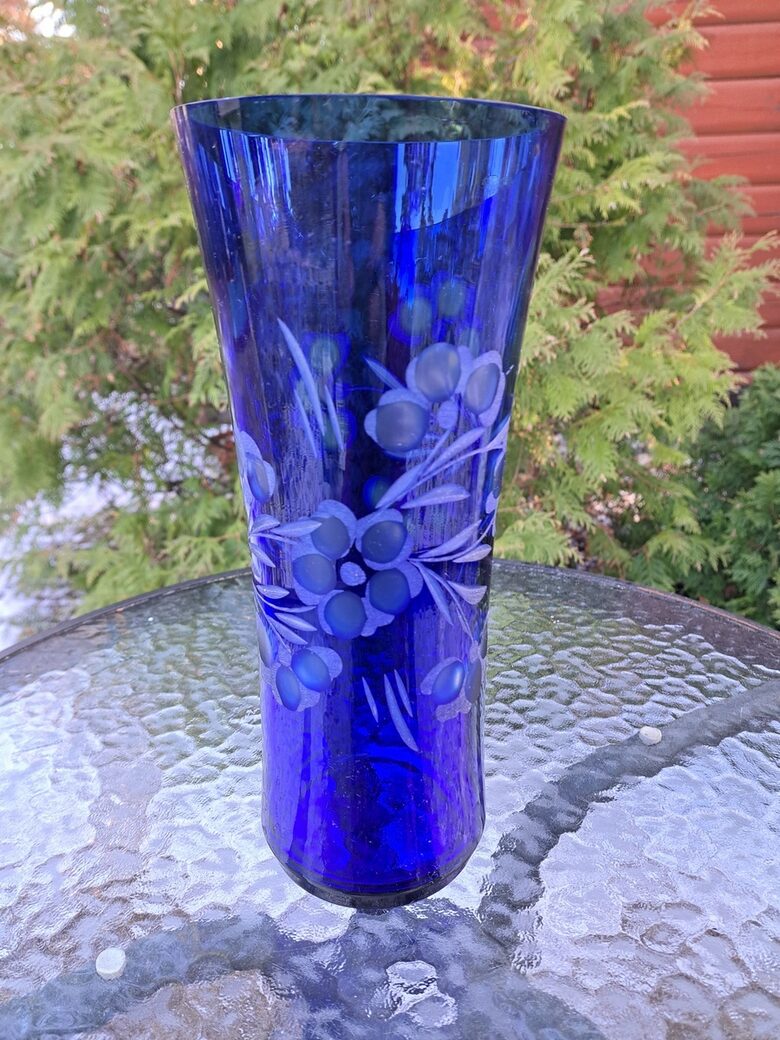 Indigo krāsas stikla vāze ar smalku puķu slīpējumu. Augstums 28cm, diam.12,2cm, nelieli defekti (Stikla vaze 149)