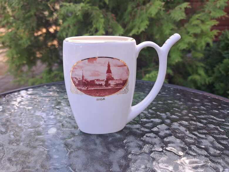 Krūzīte minerālūdenim ar Vecrīgas skatu (ovāls foto) no Daugavas un uzrakstu RĪGA ar zelta burtiem, PFF (Krūze 21)