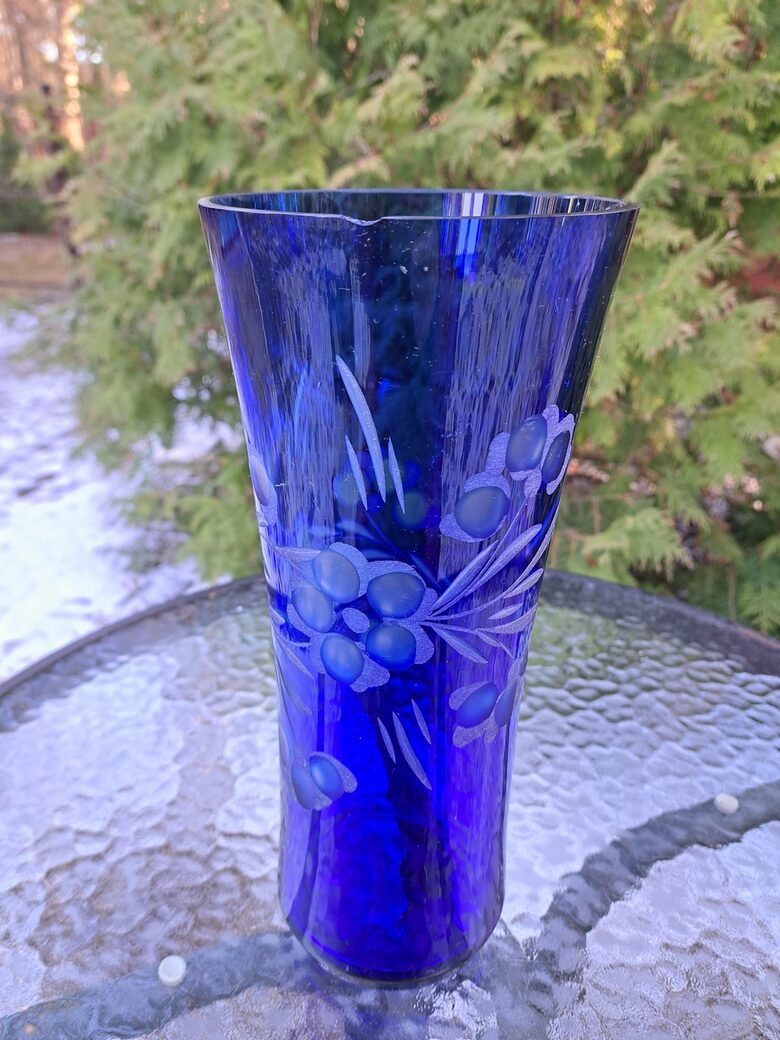 Indigo krāsas stikla vāze ar smalku puķu slīpējumu. Augstums 28cm, diam.12,2cm, nelieli defekti (Stikla vaze 149)