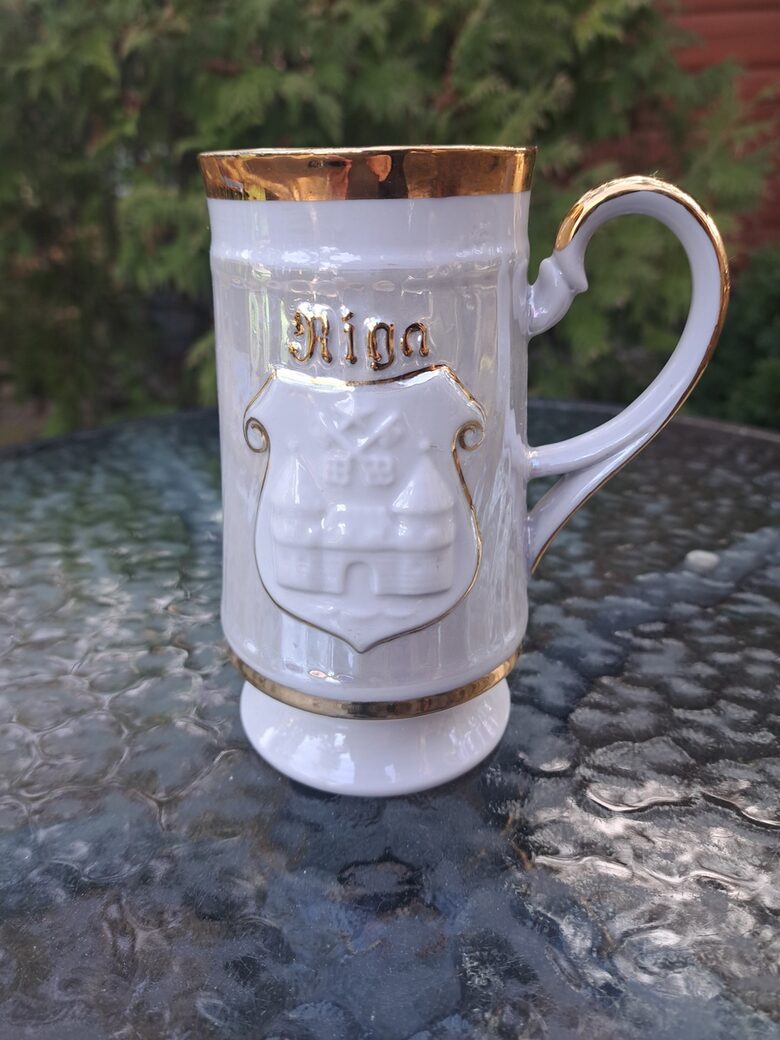 Grezns alus kauss ar Rīgas simboliku, zelts, lustrēta virsma, porcelāns, reljefa raksts, RPR . Tilpums ir 450ml (Krūze 05)