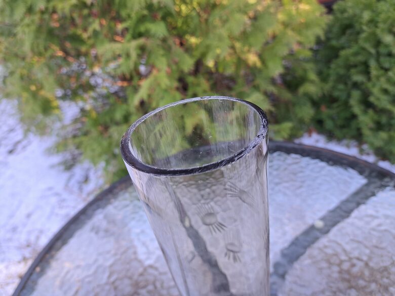 Brūngana (gaišāks tonis) cilindriskā stikla vāze ar smalku puķu grāvēšanu. Augstums 25,5cm, diam.7,5cm (Stikla vaze 151)