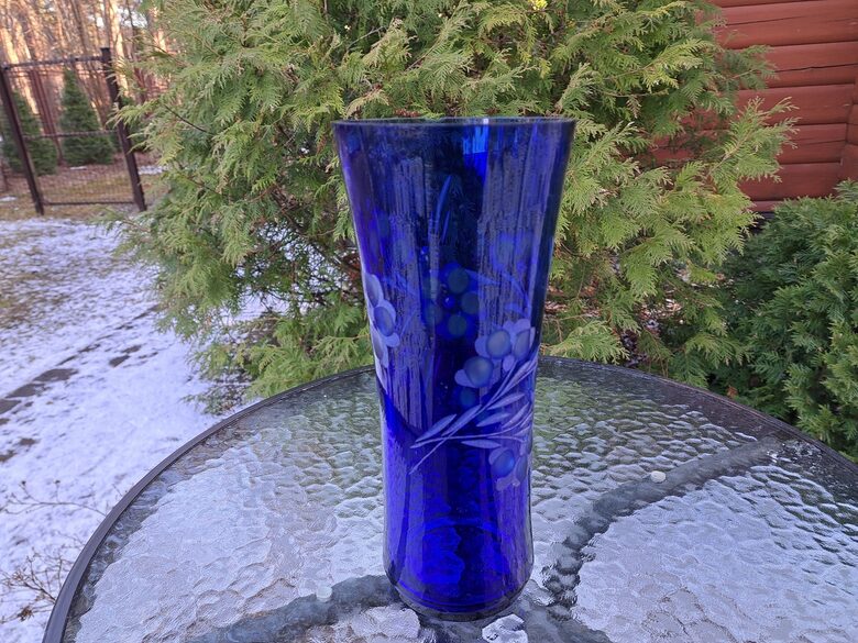 Indigo krāsas stikla vāze ar smalku puķu slīpējumu. Augstums 28cm, diam.12,2cm, nelieli defekti (Stikla vaze 149)