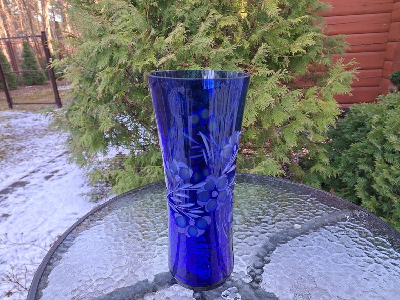 Indigo krāsas stikla vāze ar smalku puķu slīpējumu. Augstums 28cm, diam.12,2cm, nelieli defekti (Stikla vaze 149)