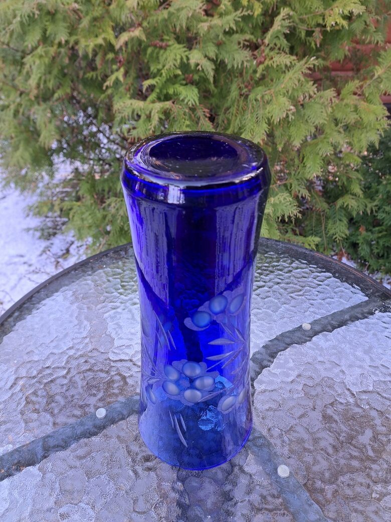 Indigo krāsas stikla vāze ar smalku puķu slīpējumu. Augstums 28cm, diam.12,2cm, nelieli defekti (Stikla vaze 149)