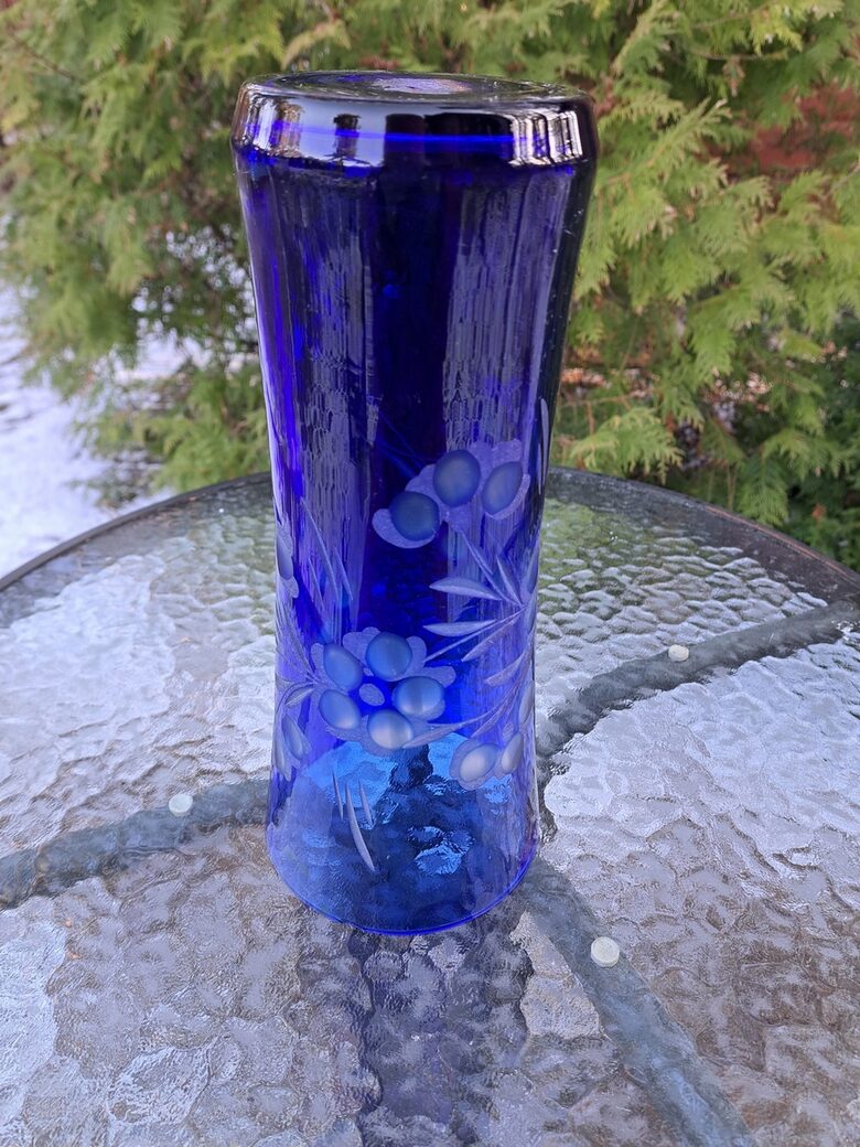 Indigo krāsas stikla vāze ar smalku puķu slīpējumu. Augstums 28cm, diam.12,2cm, nelieli defekti (Stikla vaze 149)
