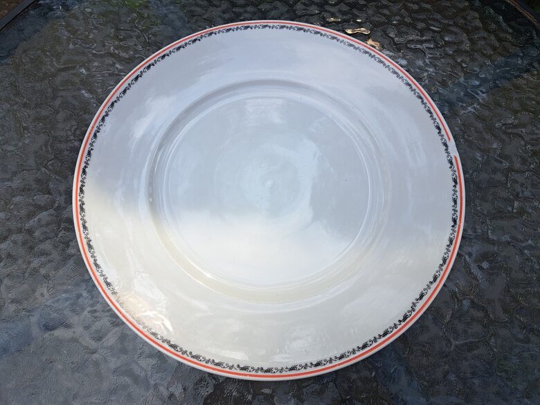Vidējais servējamais šķīvis ar melnu vainadziņu un sarkanu apvilkumu, no pusdienu servīzes. D=27cm (Jessen 48)