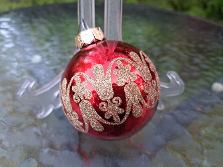 Sarkana bumba ar greznu zelta rakstu. Stikls. d=6cm (Egle bumba 57)