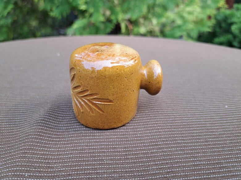 Sāls trauks ar rokturi, māls, tautīsks raksts, glazūra. Roku darbs. Augstums 4,5cm (Keram 139)