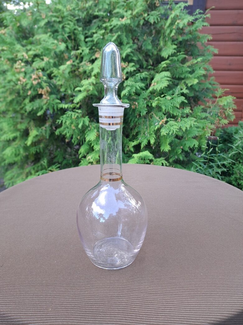 Eleganta apaļa ar garu kakliņu, korķi un zelta apvilkumiem stikla karafem. Augstums ar korķi korķa 29cm, NEMAN (Karafe st 87)