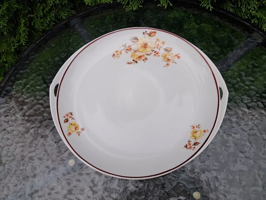 Šķīvis servējamais ar rokturiem un dzeltenām rozēm (dekols), brūnu apvilkumu, Rīgas Keramikas Fabrika (Kuzņecovs 179)