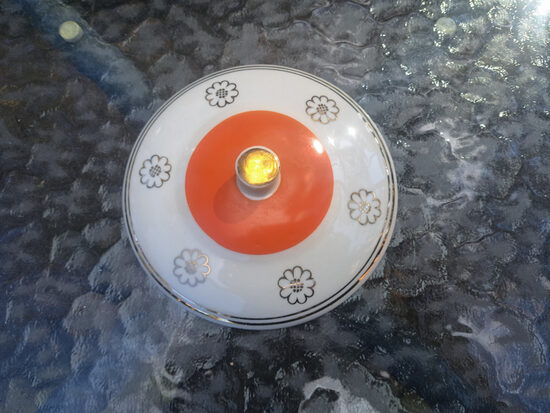 Sviesta trauka vāks balts ar sarkanu pārklajumu, zelta apvikumu un zelta puķēm, ražotājs nav zinams. Diametrs ārējais: 13cm (Citi rpt 344)