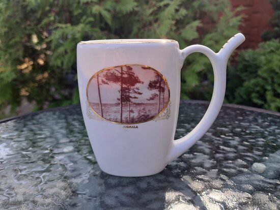 Krūzīte minerālūdenim ar Jūrmalas skatu (ovāls foto) un uzrakstu Jūrmala ar zelta burtiem, plaisas. PFF (Krūze 25)