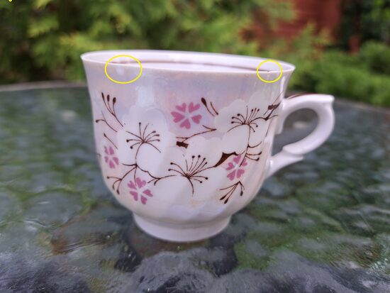 Krūzīte  ar ķiršu ziediem, lustru un brūnu šauru apvilkumu iekšā, sīki nošķēlumi gar malu (Rīga 80 115)