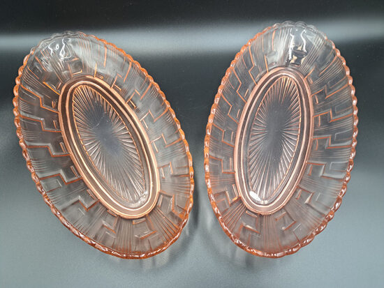 Izsmalcināti garenie šķīvji, presēts maigi rozā stikls ar ģeometrisku rakstu. Izmēri: 28cm x 14cm; h=4,5cm. LORUP (Stikls sk 324)