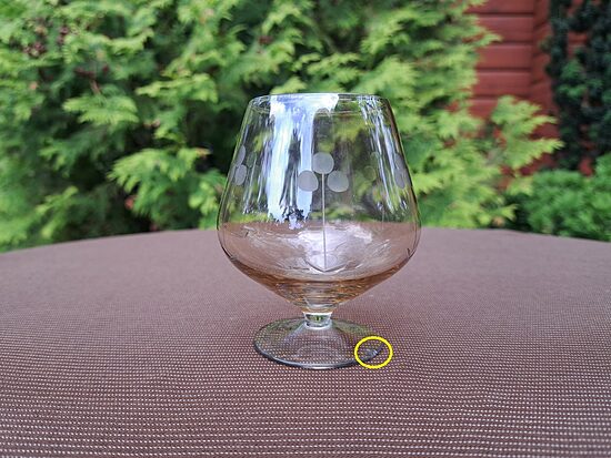 Konjaka glāze uz kājiņas, viegla maigi dzeltena lustra, puķu gravēšana. Tilpums 225ml. Nošķelums uz palatnes (Stikla gl 476)