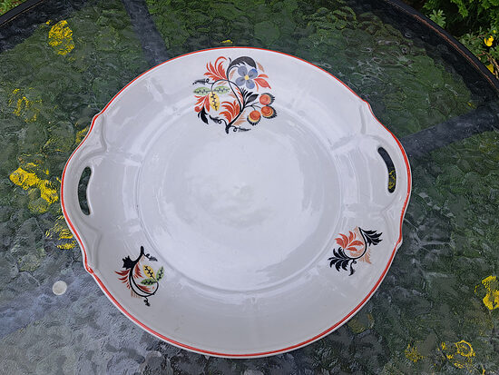 Servējamais šķīvis ar rokturiem, sarkanu un melnu dekolu un sarkanu apvilkumu, porcelāns, Rīgas Keramikas Fabrīga ar zvaigzni. Periods - 1940.-41.g.g. (Kuzņecovs 196)
