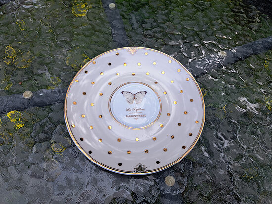 Apakštase porcelāna ar jauku ziloņkaula pārklājumu, zelta punktiņiem, taureni un Les Papillons,  Jardin Secret uzrakstu centrā. Apakštases diametrs 16,5cm (Citi rpt 362)