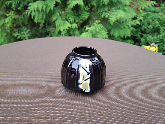 Mazā mucaveida vāzīte, tumši brūna, dzelteni elementi, reljefa forma, glancēta glazūra. D-8,5cm, h=7cm (Keram vāze 74)