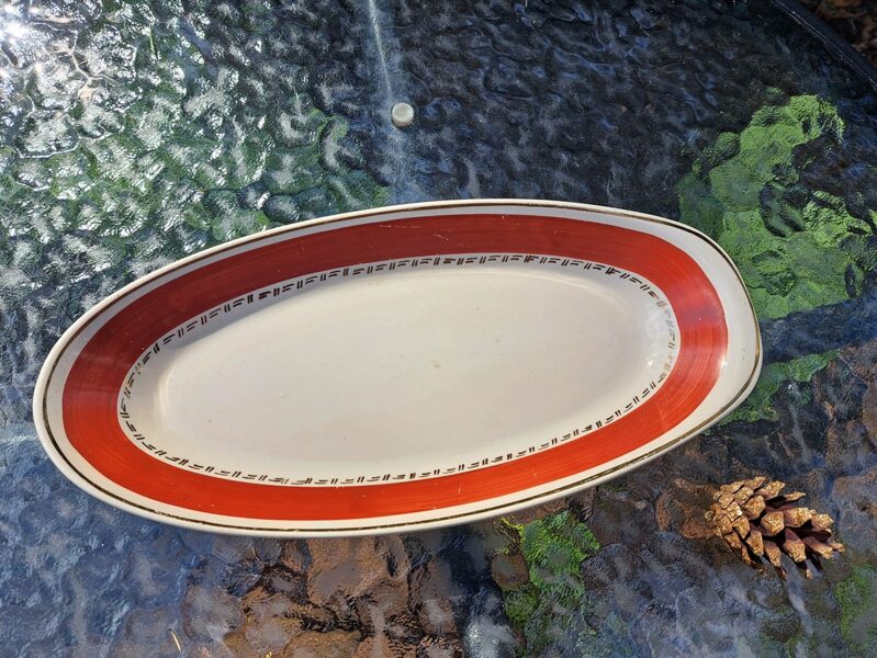 Servējamais garenais šķīvis 27,5cmx13cm, balts ar platu tumši sarkanu malu un zeltu, pusdienu servīze "Jaunā" (Jaunā 17)