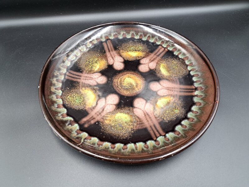 Skaists dekoratīvs tumšī brūns ar zaļgānu dekoru keramikas šķīvis, Latgales keramika (Keram 88)