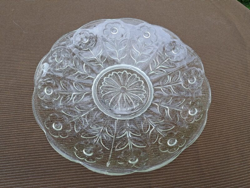 Vintāžs caurspīdīgs presēta stikla šķīvis, ar puķu rakstu un mikro burbuļiem stiklā. Diam. 21,8cm (Stikls sk 210)