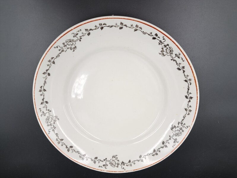 Otrā ēdiena šķīvis d=23,5cm, pirmskara forma, Rīgas PF. Sarkana mala un melns vainadziņš ar rozi (Pirmskara 26)