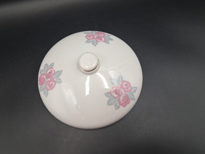 Sviesta trauka vāks balts ar rozā rozītēm un zeltu uz roktura, ražotājs nav zinams. (Citi rpt 40)