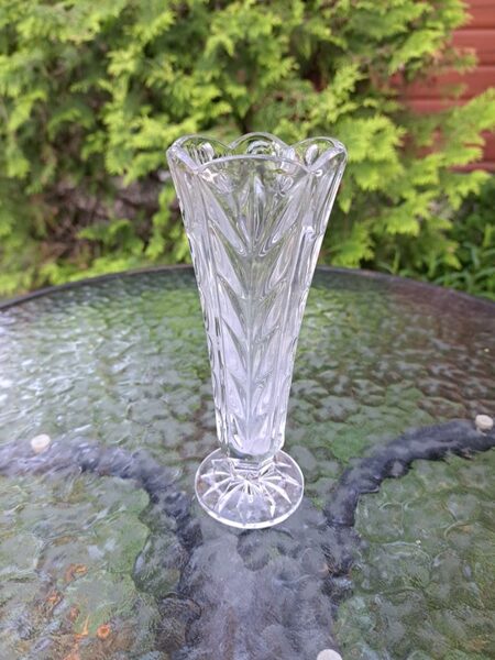 Caurspīdīga vāzīte uz kājīņas ar reljefa rakstu, presēts stikls. Lielisks stāvoklis, bez defektiem. H=17,5cm (Stikla vāze 120)