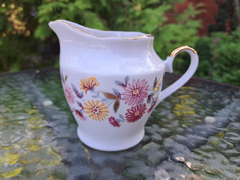 Krējuma kanniņa no brīnīšķīgas kafijas servīzes "Ārija" ar rozā un dzeltenām puķēm, pelēkām lapiņām un zeltu, RPR (Ārija kafijas 120)