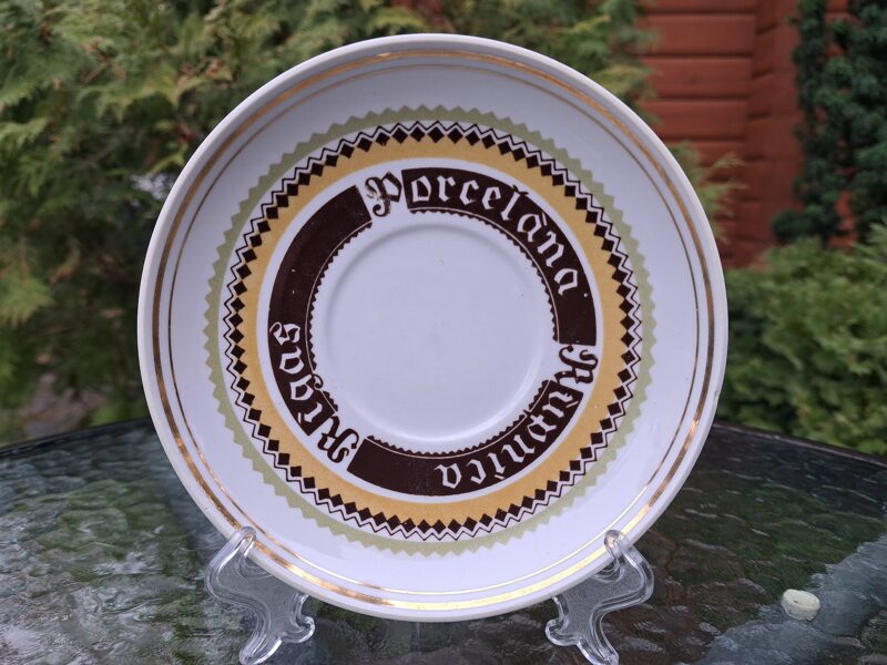 Lielā apakštase ar zīmējumu un uzrakstu Rīgas porcelāna fabrika un zeltu, no komplekta "Apetīte", RPR. Diametrs 15,6cm (Buljona 168)